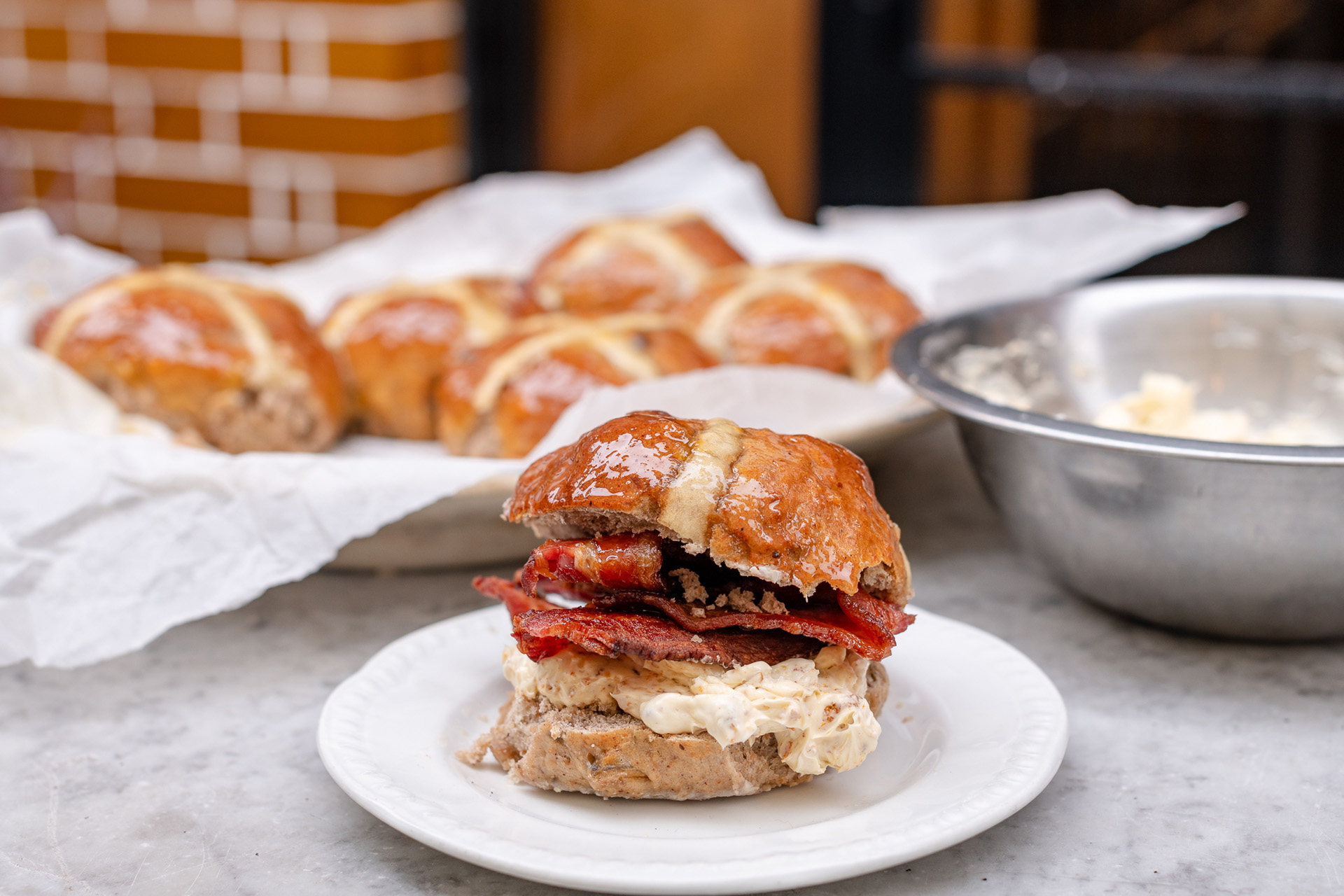 A hot cross bun with bacon