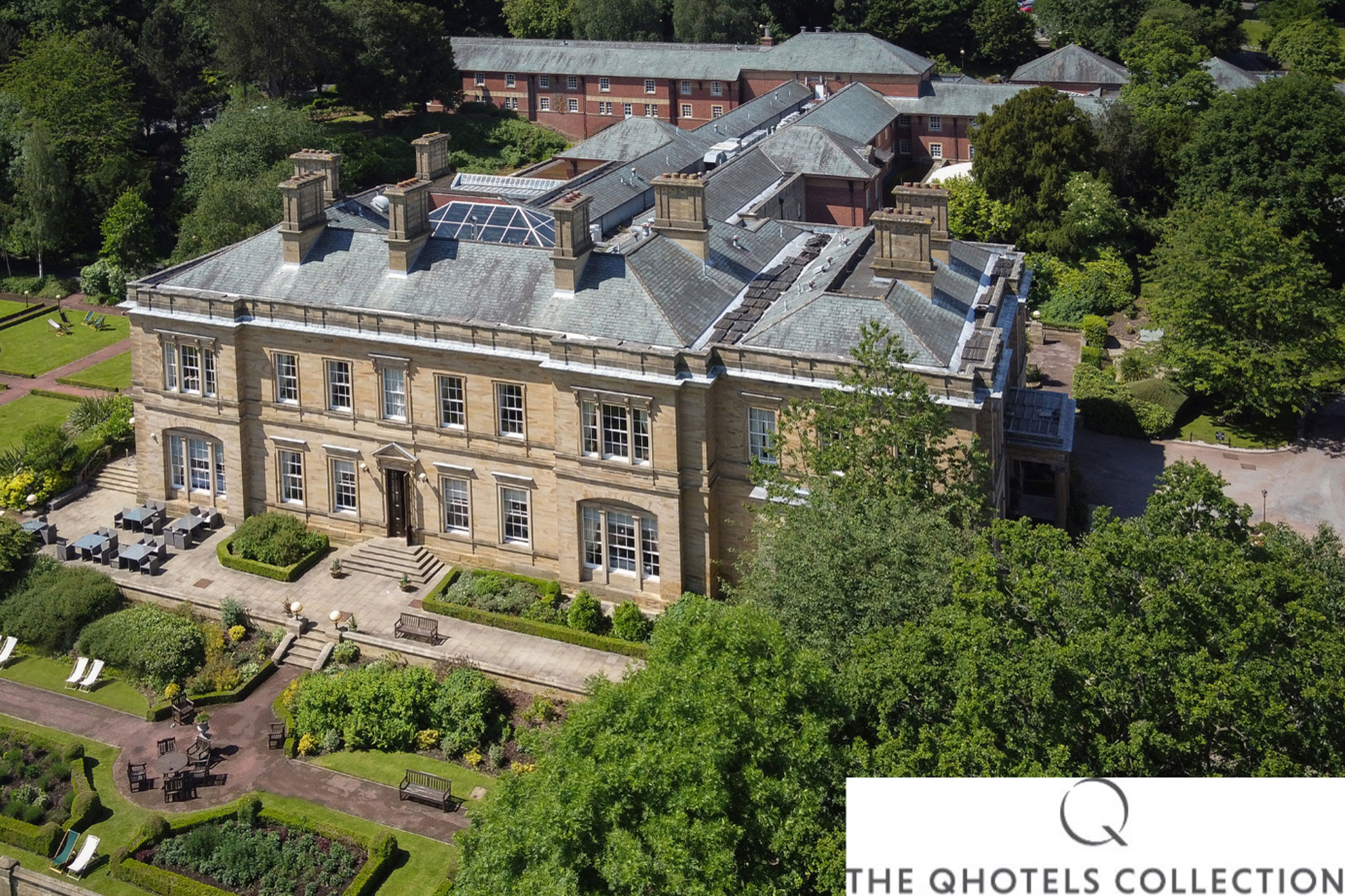Aerial view of manor house hotel with lawns surrounding