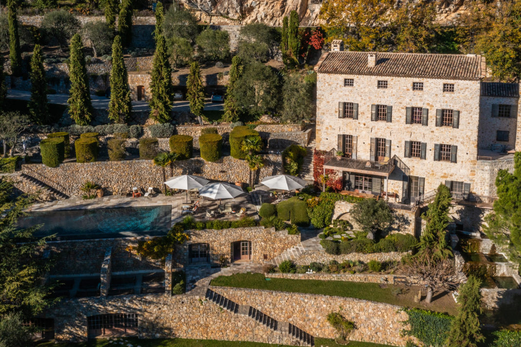 Aerial view of mill conversion with an outdoor pool and hills surrounding it.