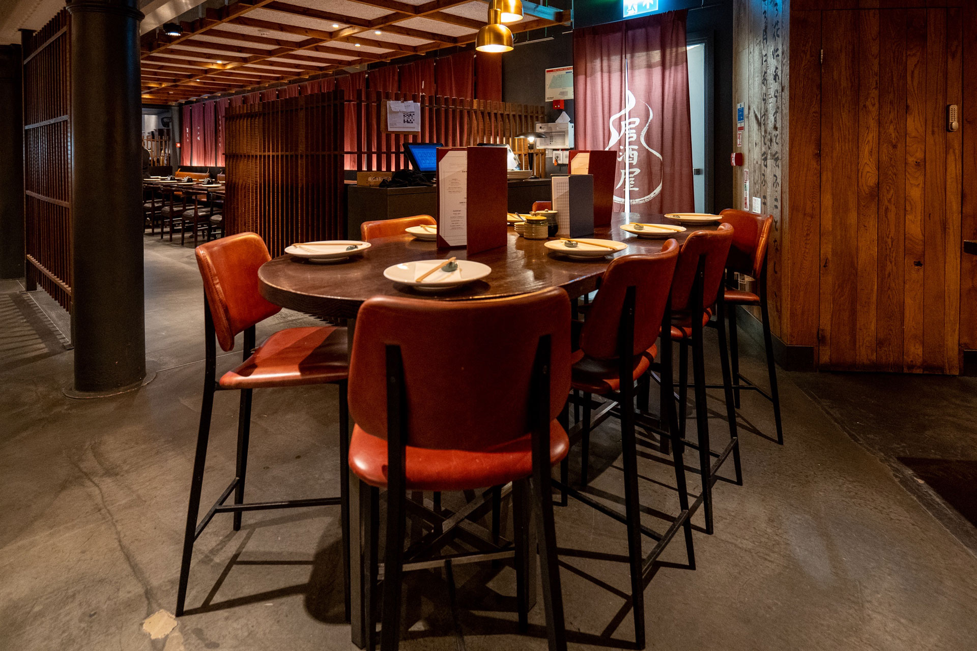 Flesh & Buns Covent Garden restaurant, with red leather chairs and dark wooden tables.