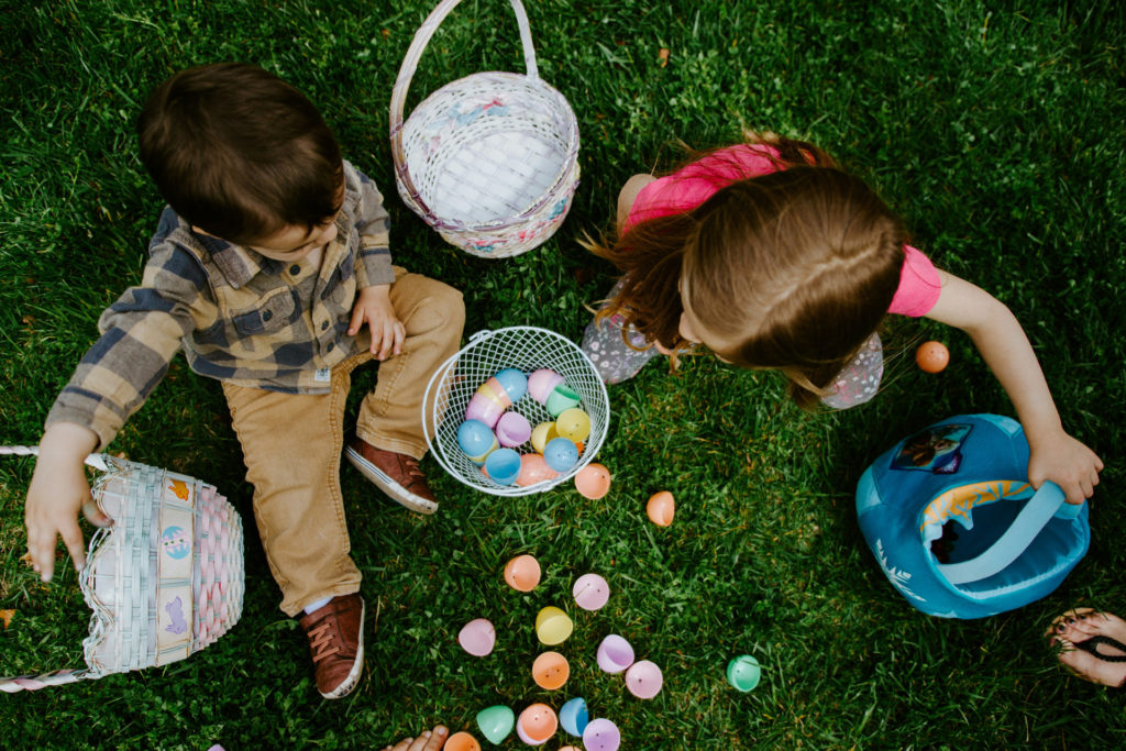 Two children sat with the eggs they collected on an Easter egg hunt