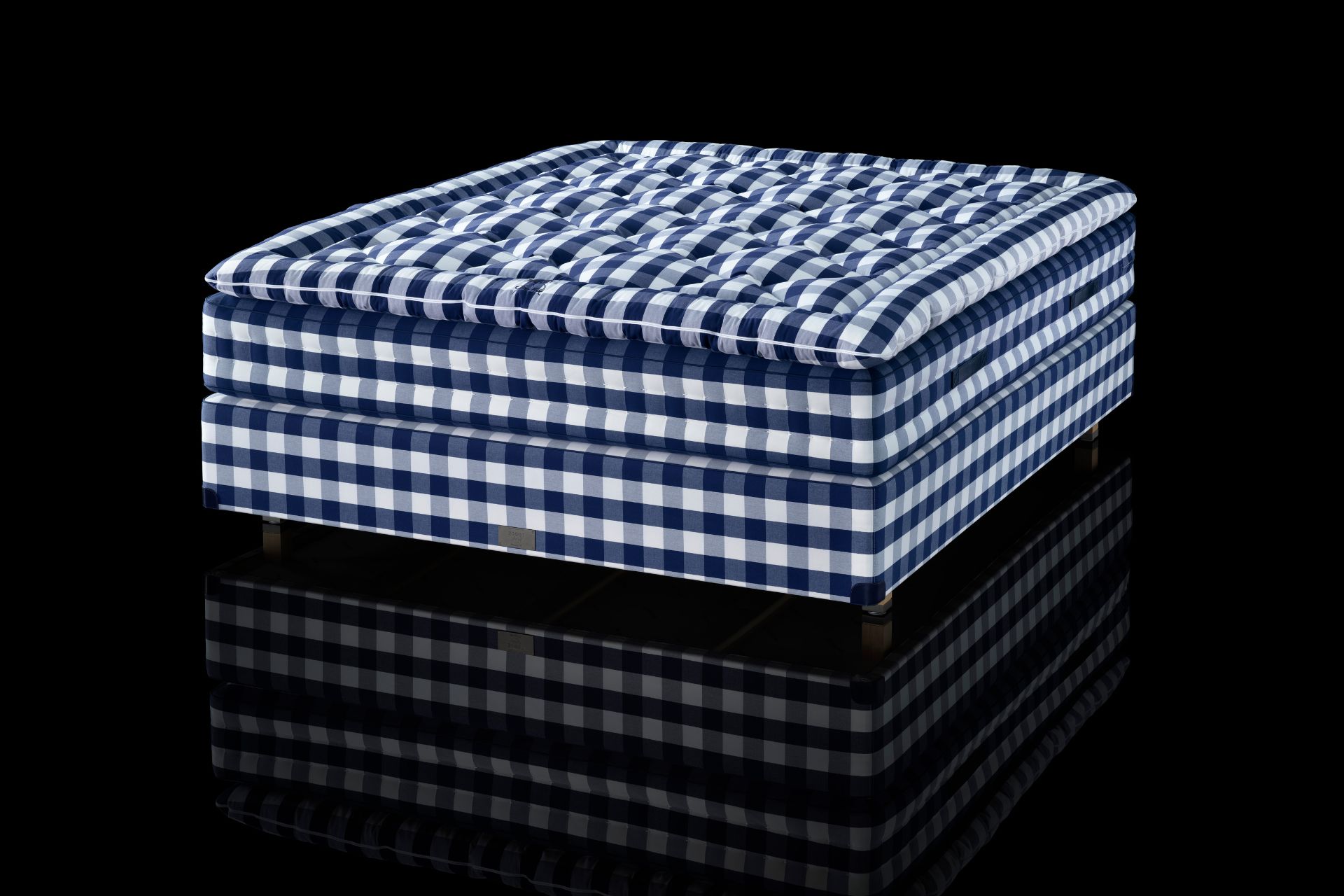 Hastens blue and white check mattress against black background