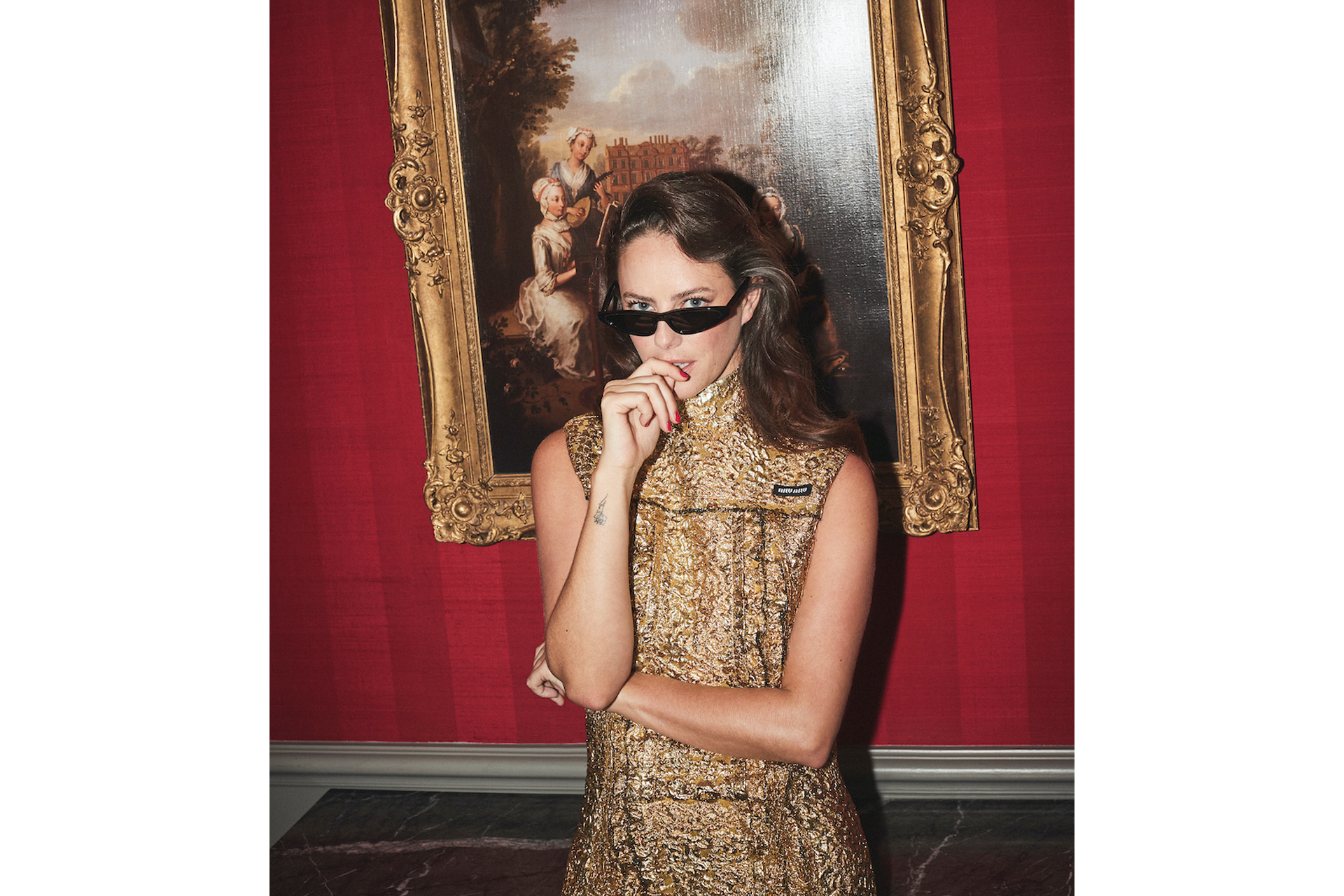 kaya scodelario photo in gold dress and sunglasses standing in front of an old painting on a red wall