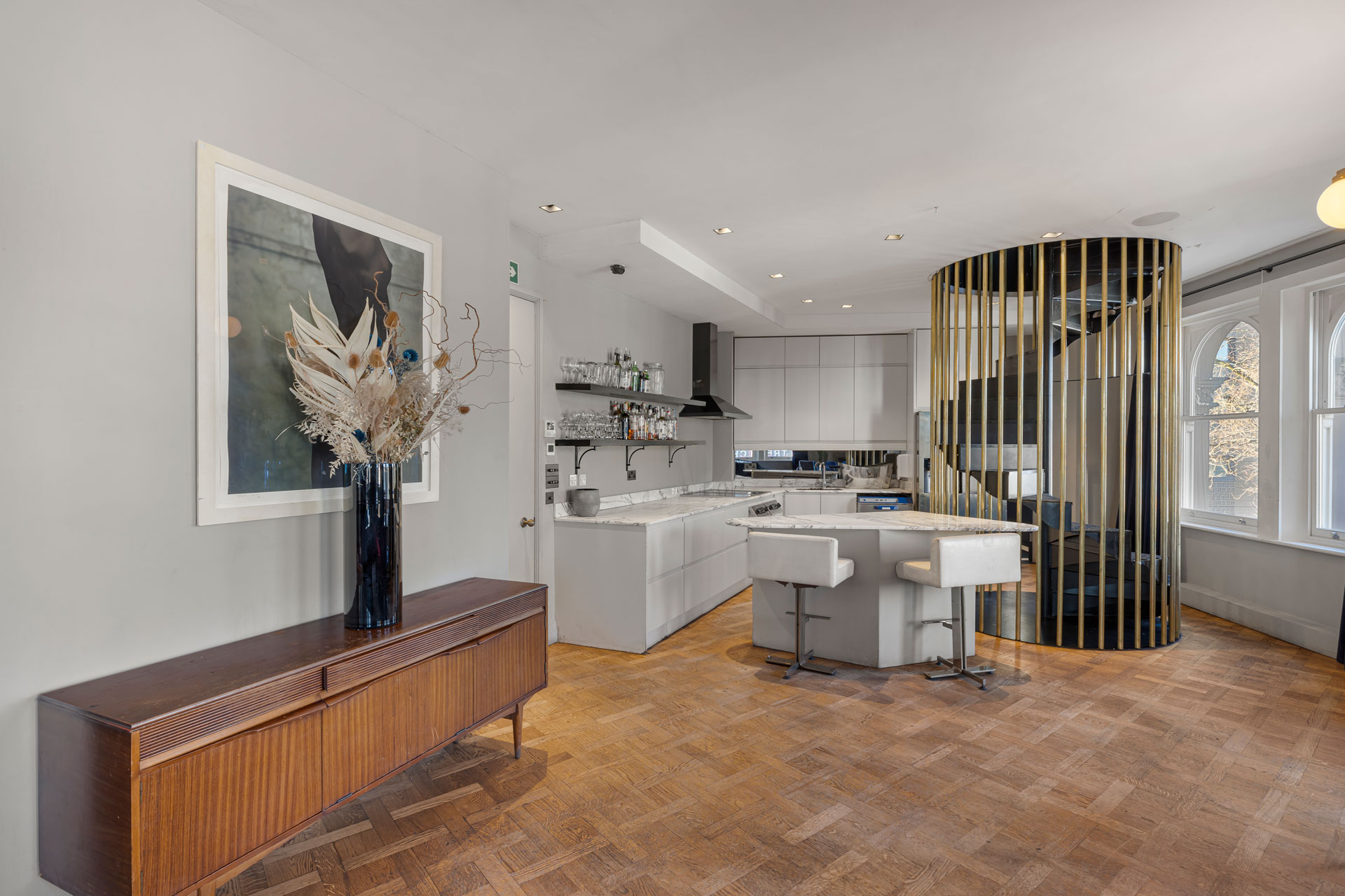 Living room with parquet flooring and a gold spiral staircase