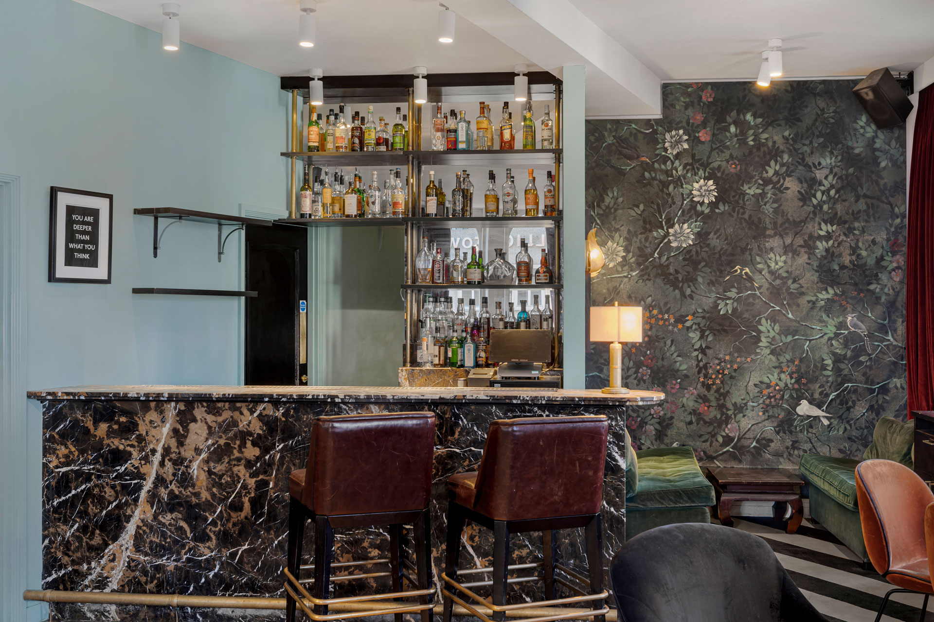 Bar with black marble surface and brown leather chairs