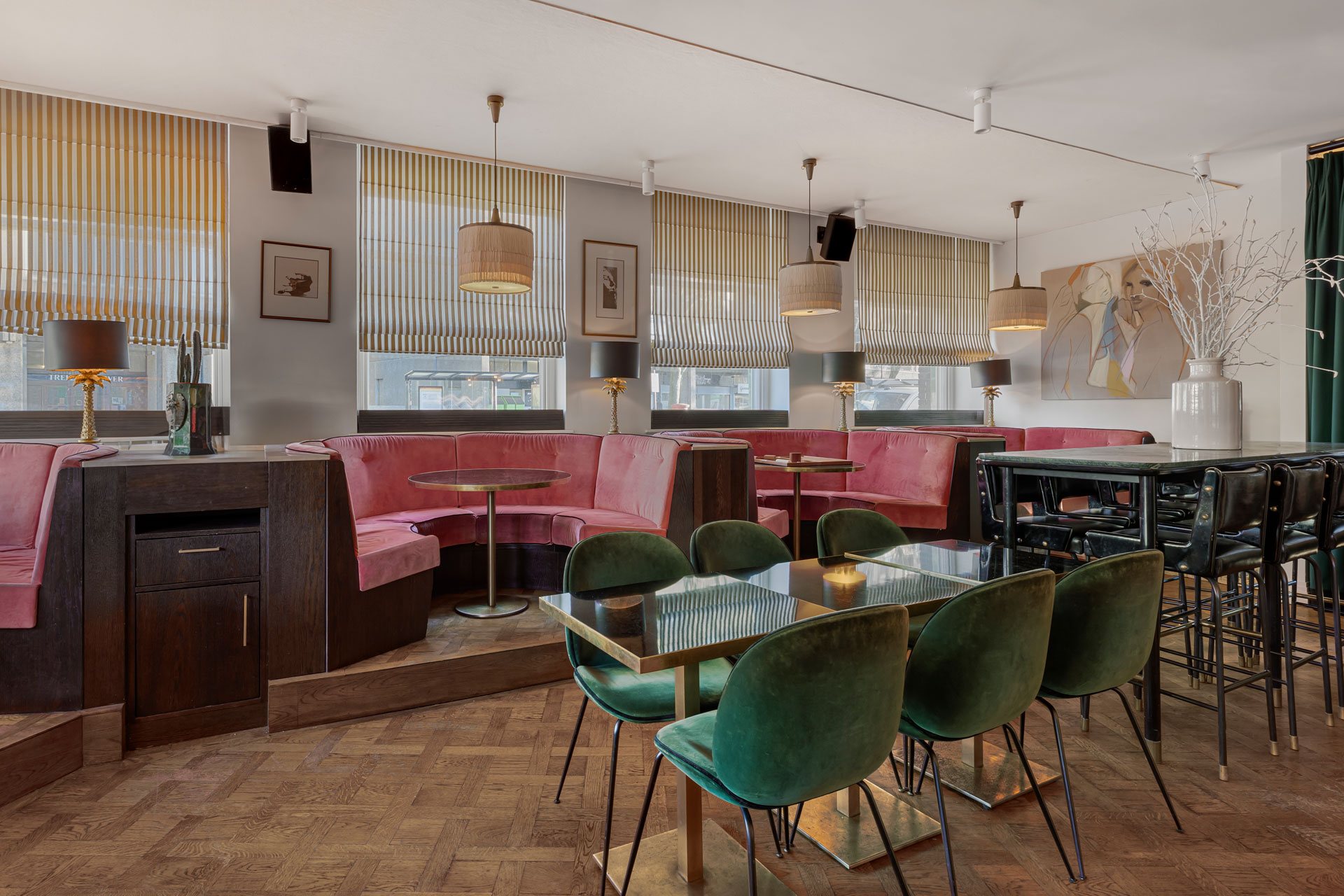 Restaurant with parquet flooring, velvet seating and black tables