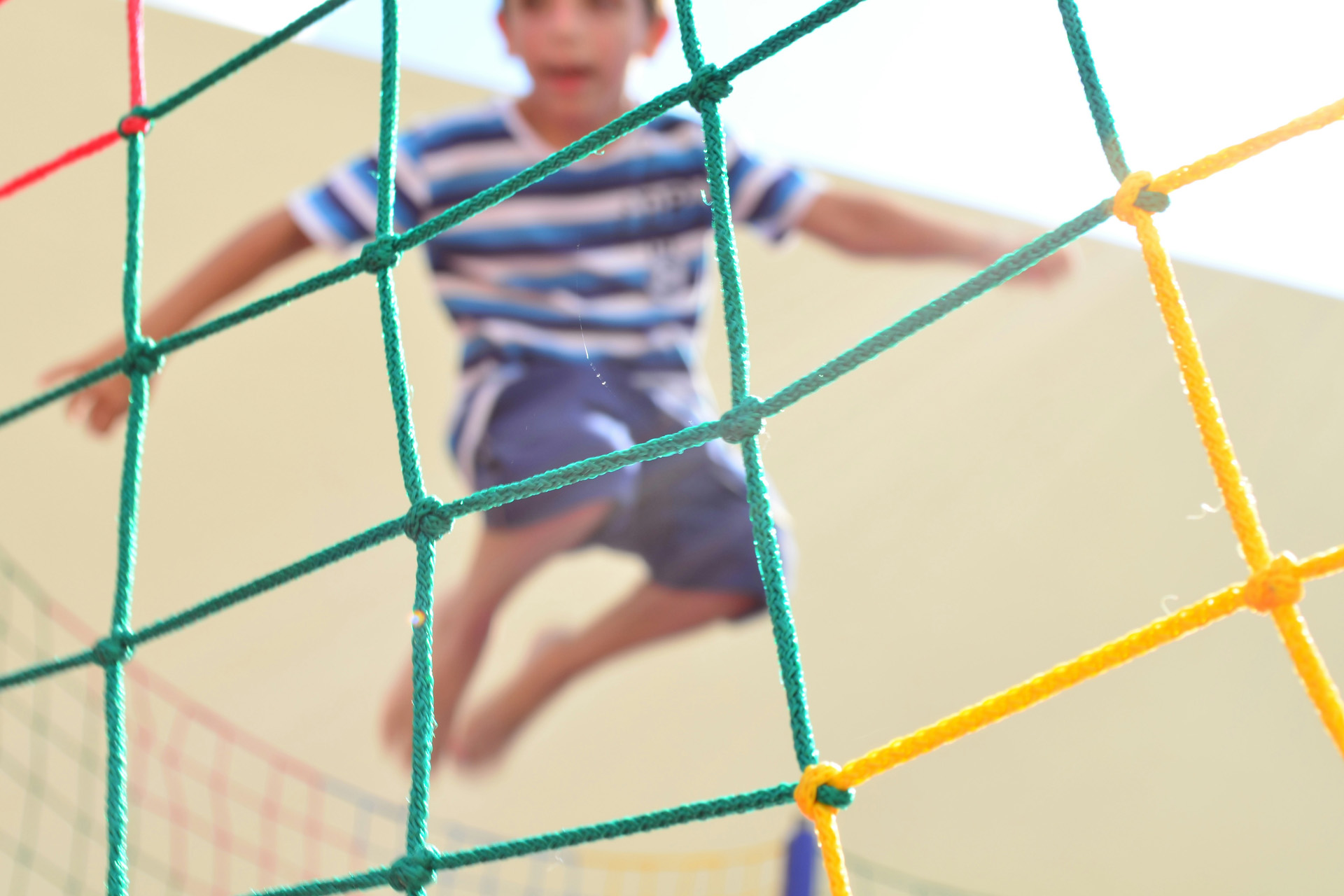 A young boy bouncing on an indoor trampoline
