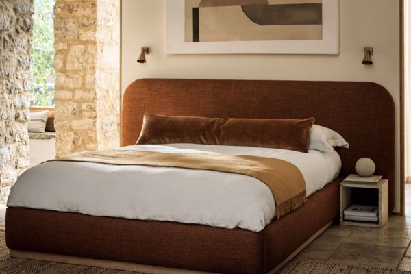 Bed with ochre velvet bedframe, white bedding, and an ochre throw