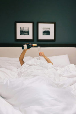 Woman pouring champagne in bed