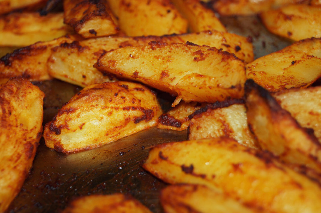 Crispy potatoes on a baking tray.