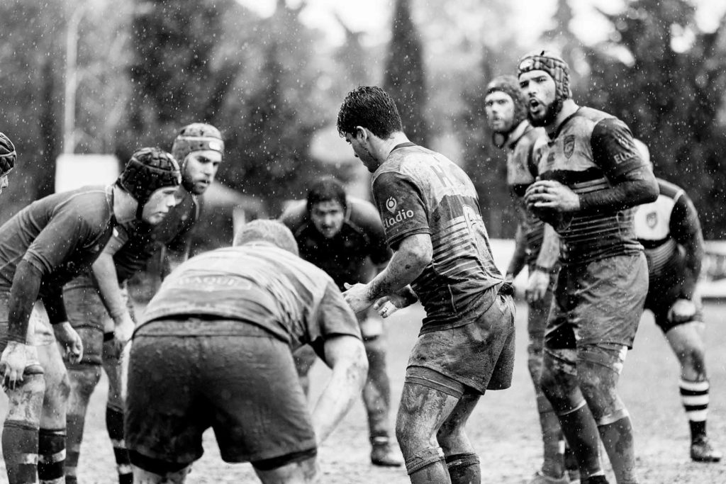 black and white image of a rugby game in the rain