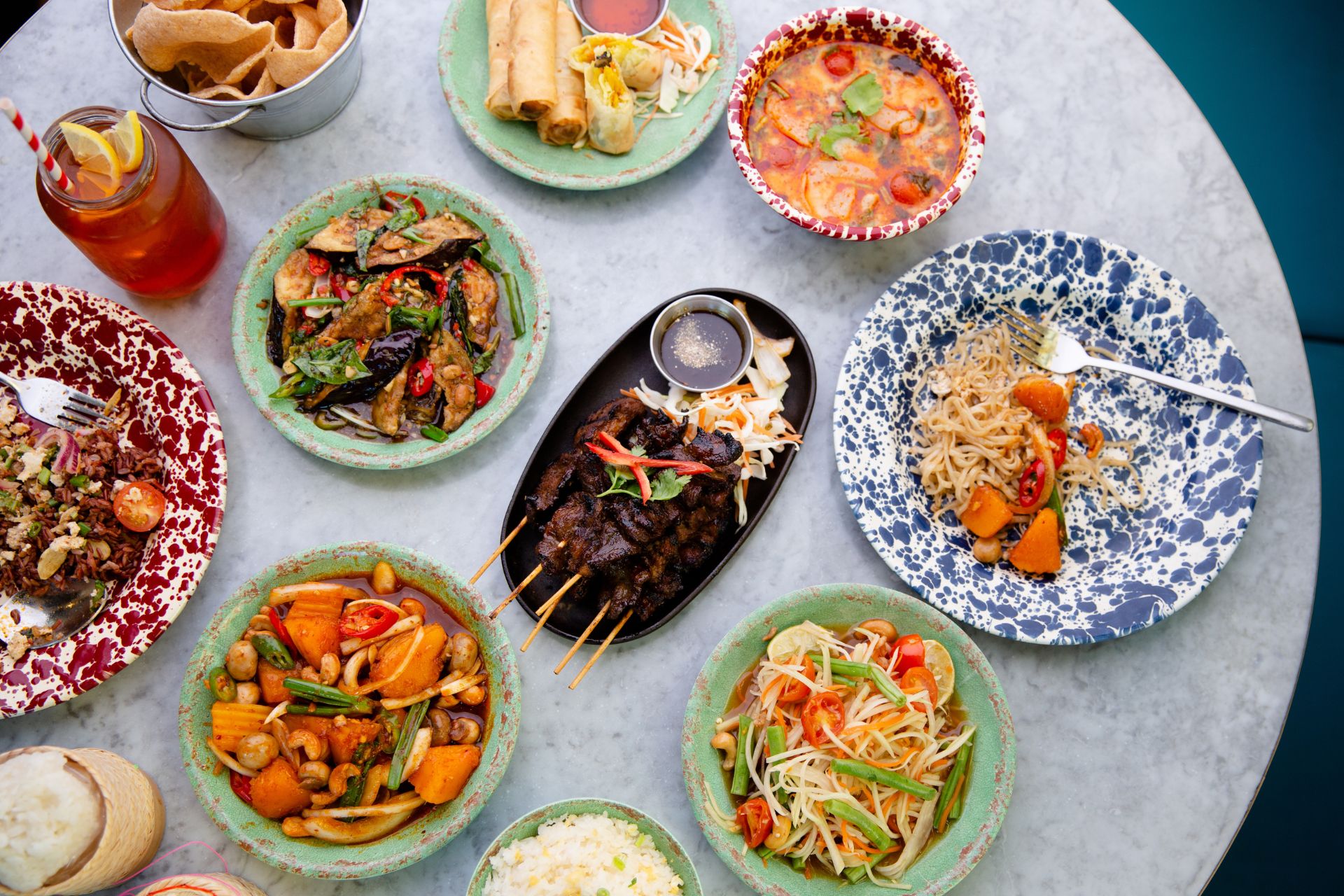 Thai dishes on a pale blue mosaic table