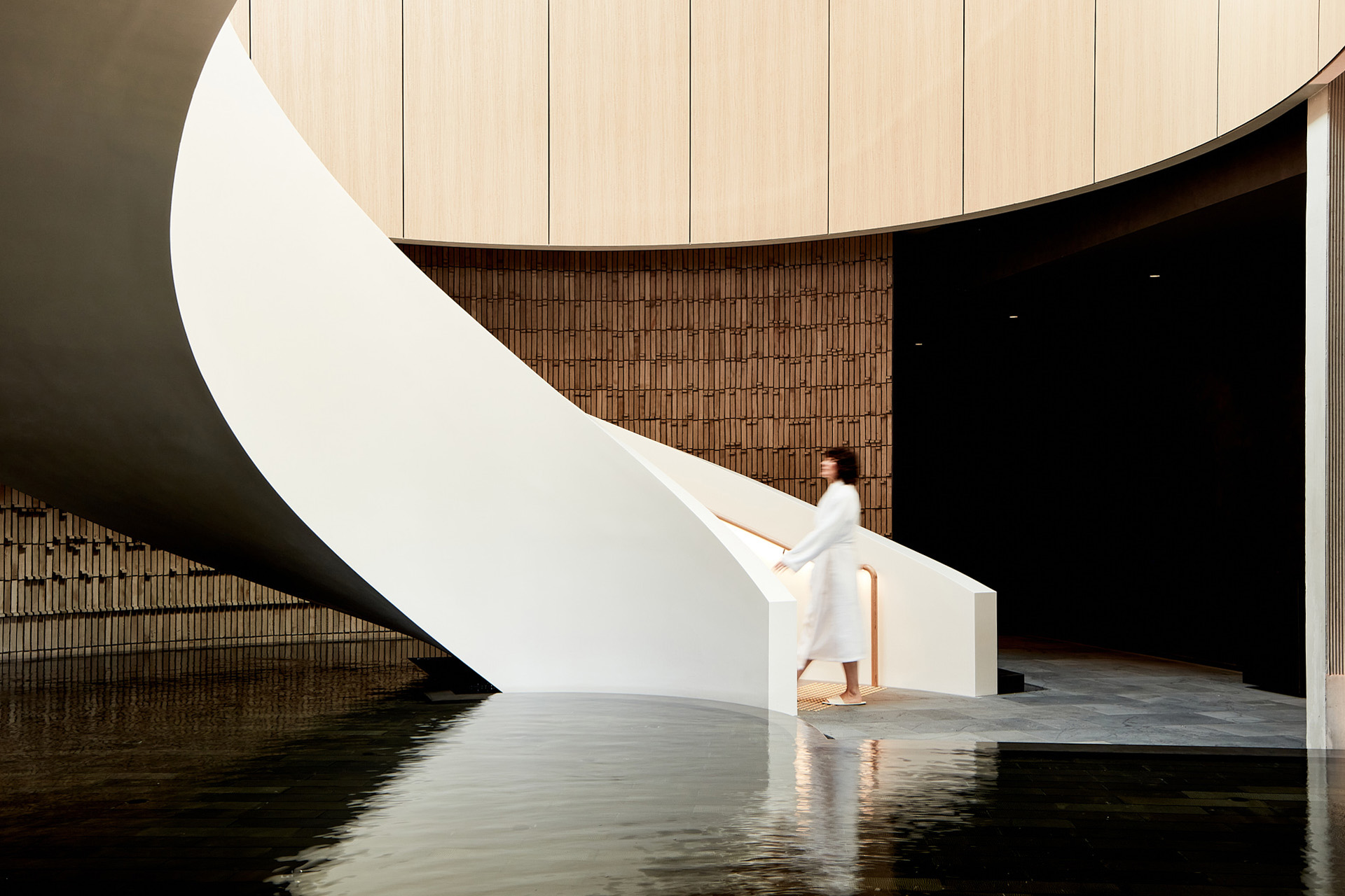 A modern staircase descending into a tranquil pool