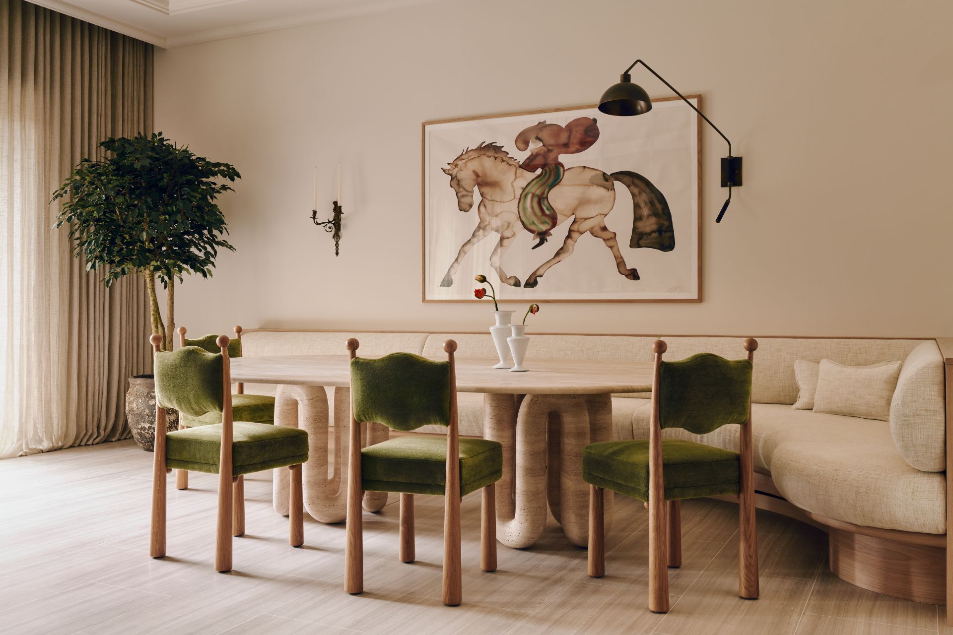 Dining area with green velvet chairs and a wooden table.