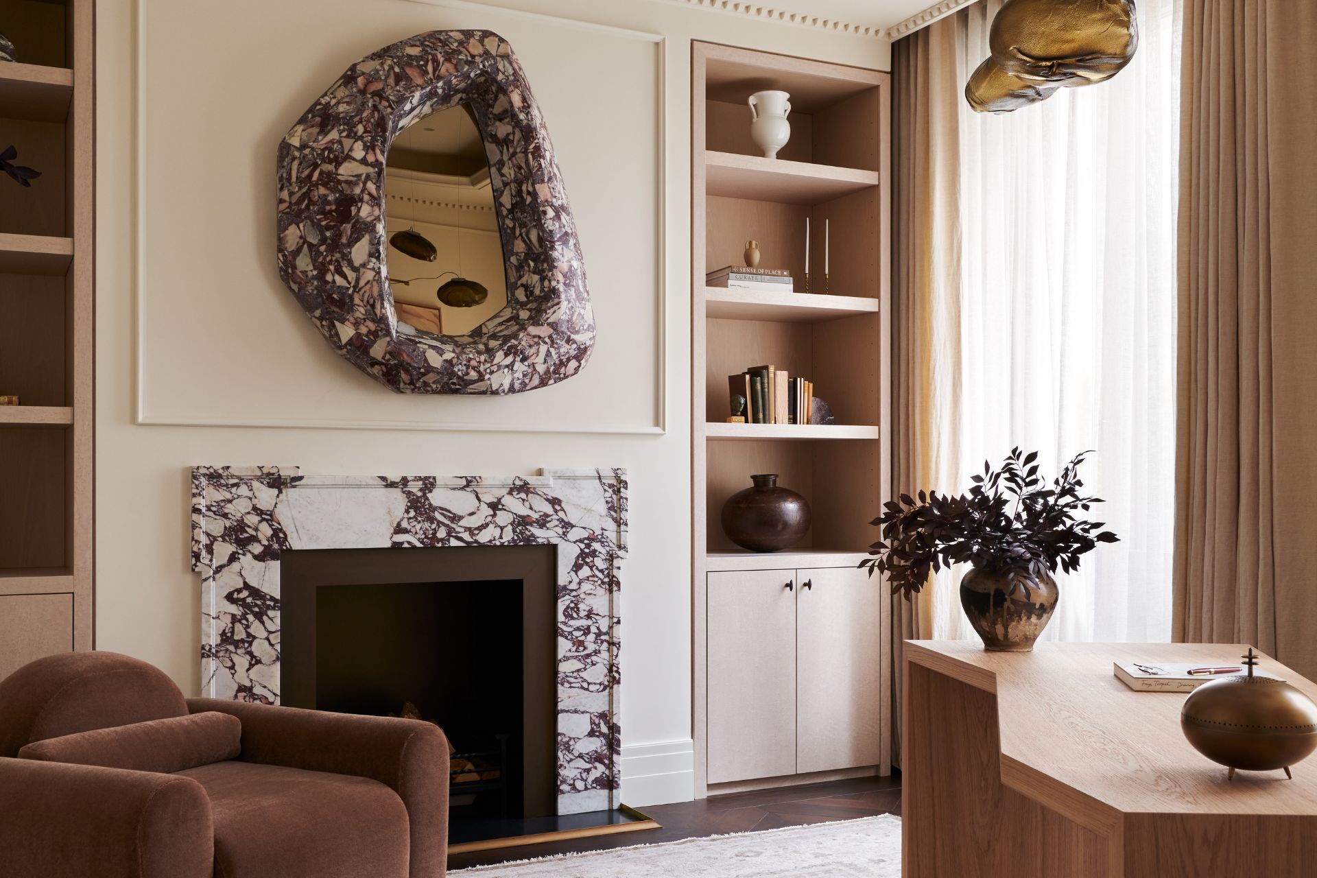 Study with marble fireplace, marble mirror and wooden desk.