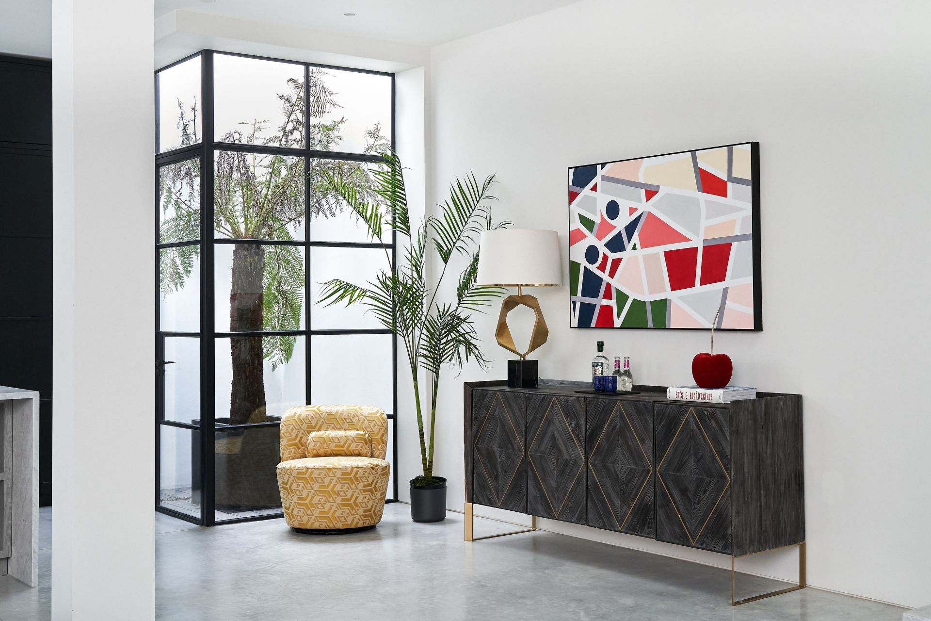 Living room with black sideboard, a yellow armchair and Crittall windows.