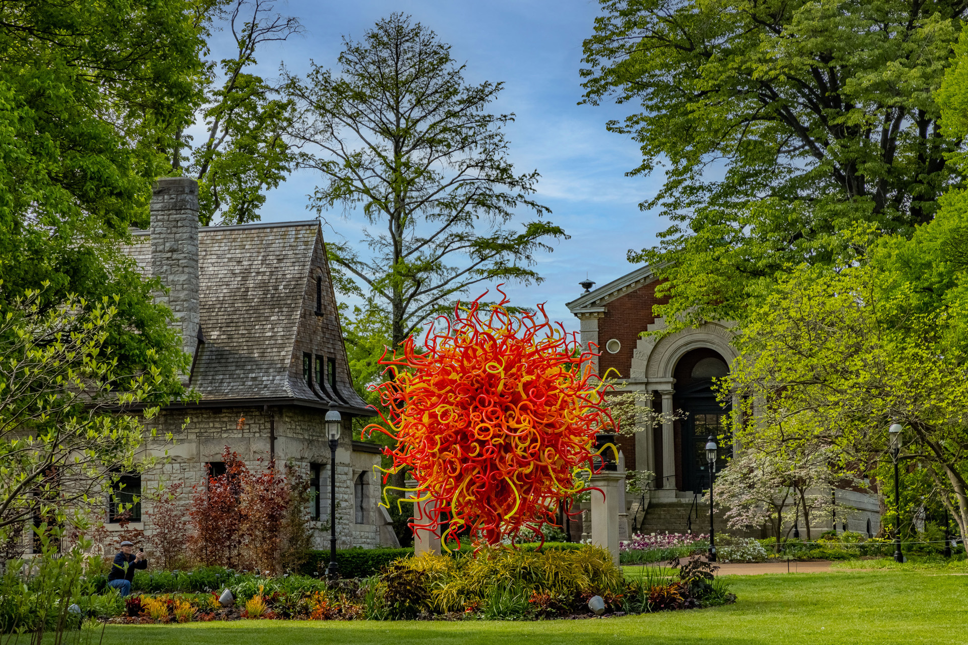 A large orange sculpture beside a church