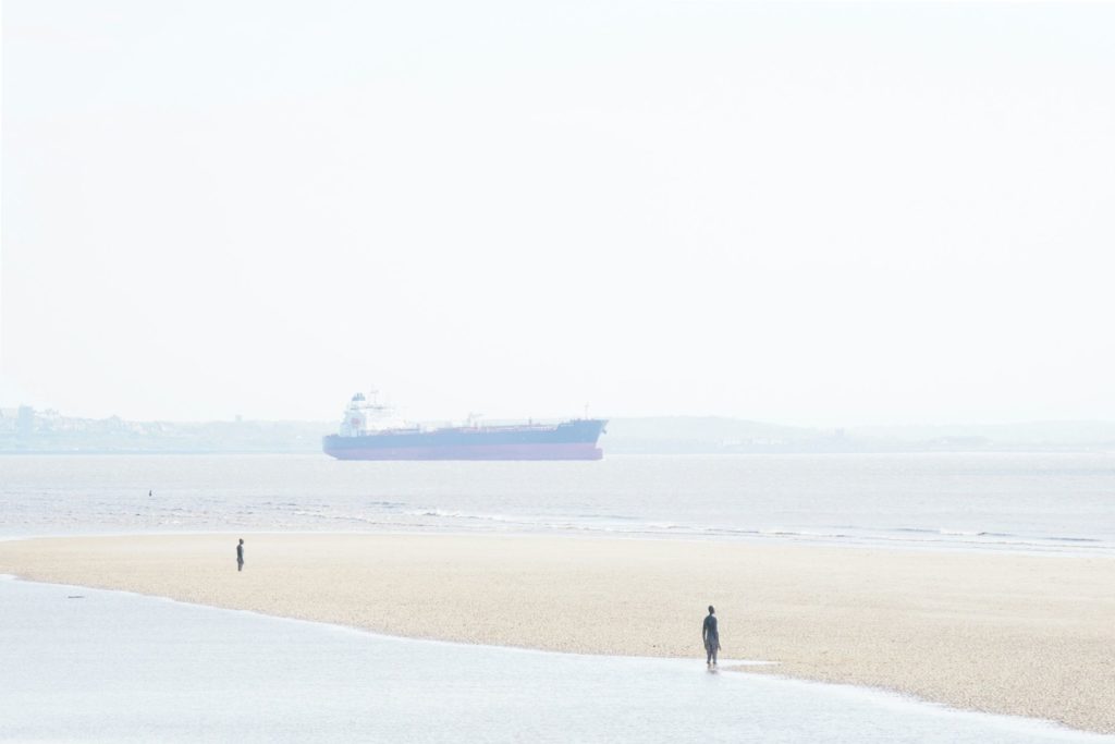 Antony Gormley's cast iron 'Another Place' sculptures facing the sea at Crosby Beach.