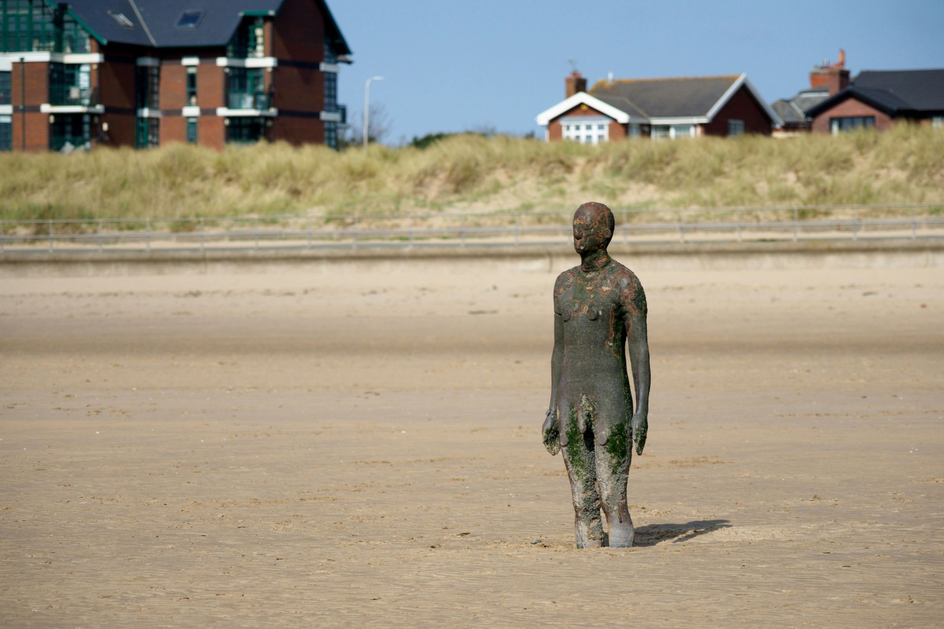 Antony Gormley's cast iron 'Another Place' sculpture facing the sea at Crosby Beach. 