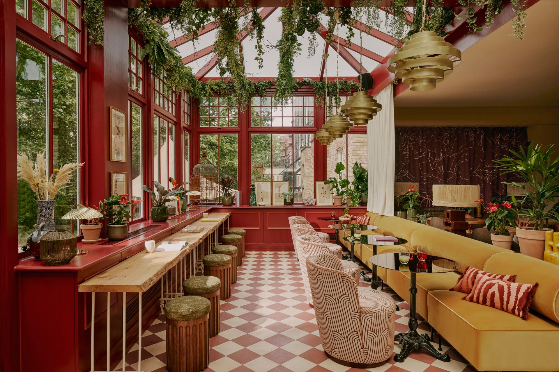 Ember Locke restaurant with beige and white diamond floor tiles, yellow banquettes, and red walls.
