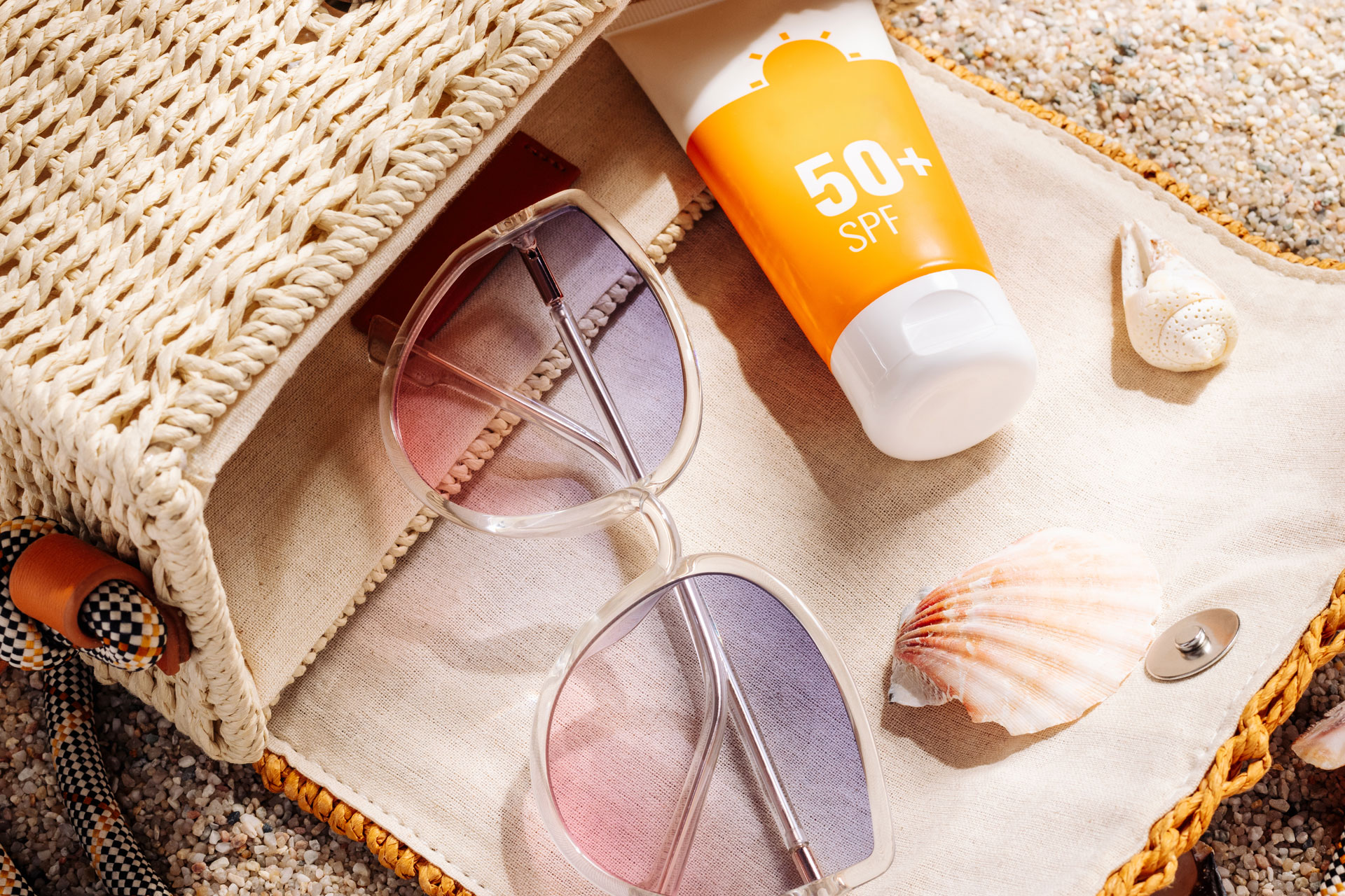 Bag with sunglasses and suncream on a beach