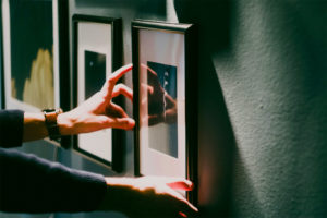 Person hanging art on a wall