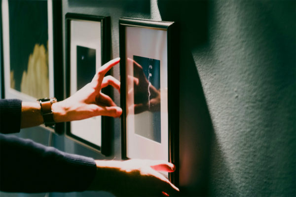 Person hanging art on a wall
