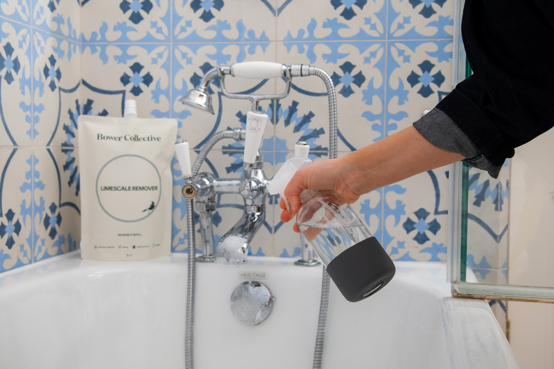 Model using limescale remover in bathroom