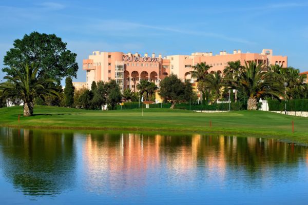 Exterior of Olivo Nova hotel, with a lake in the foreground.