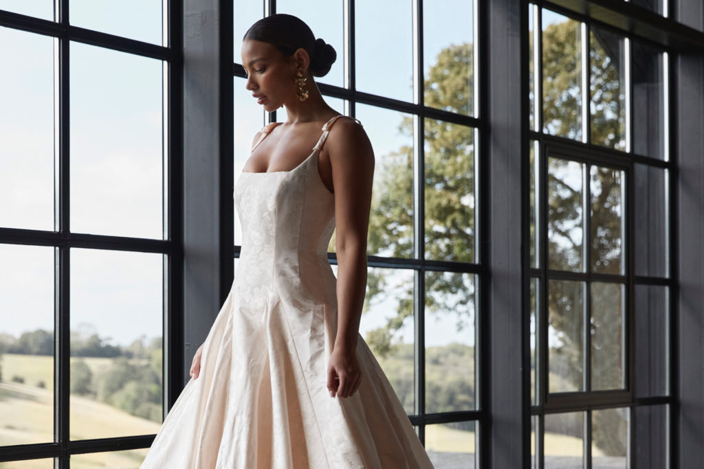 Woman stood by window in wedding dress | wedding trends 2024/2025