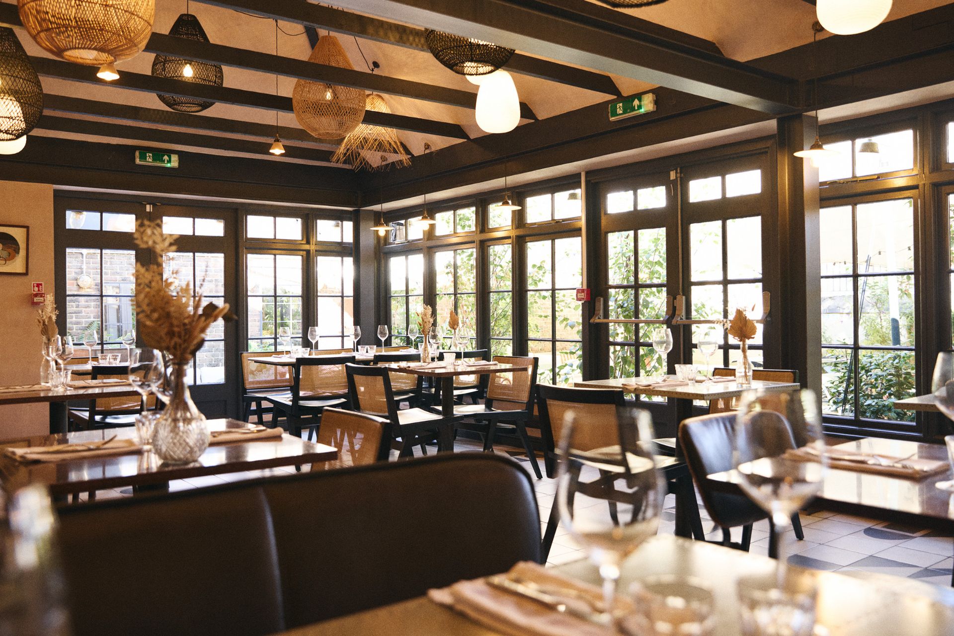 Interior of Wilding, Oxford, with wooden tables and charcoal accents.