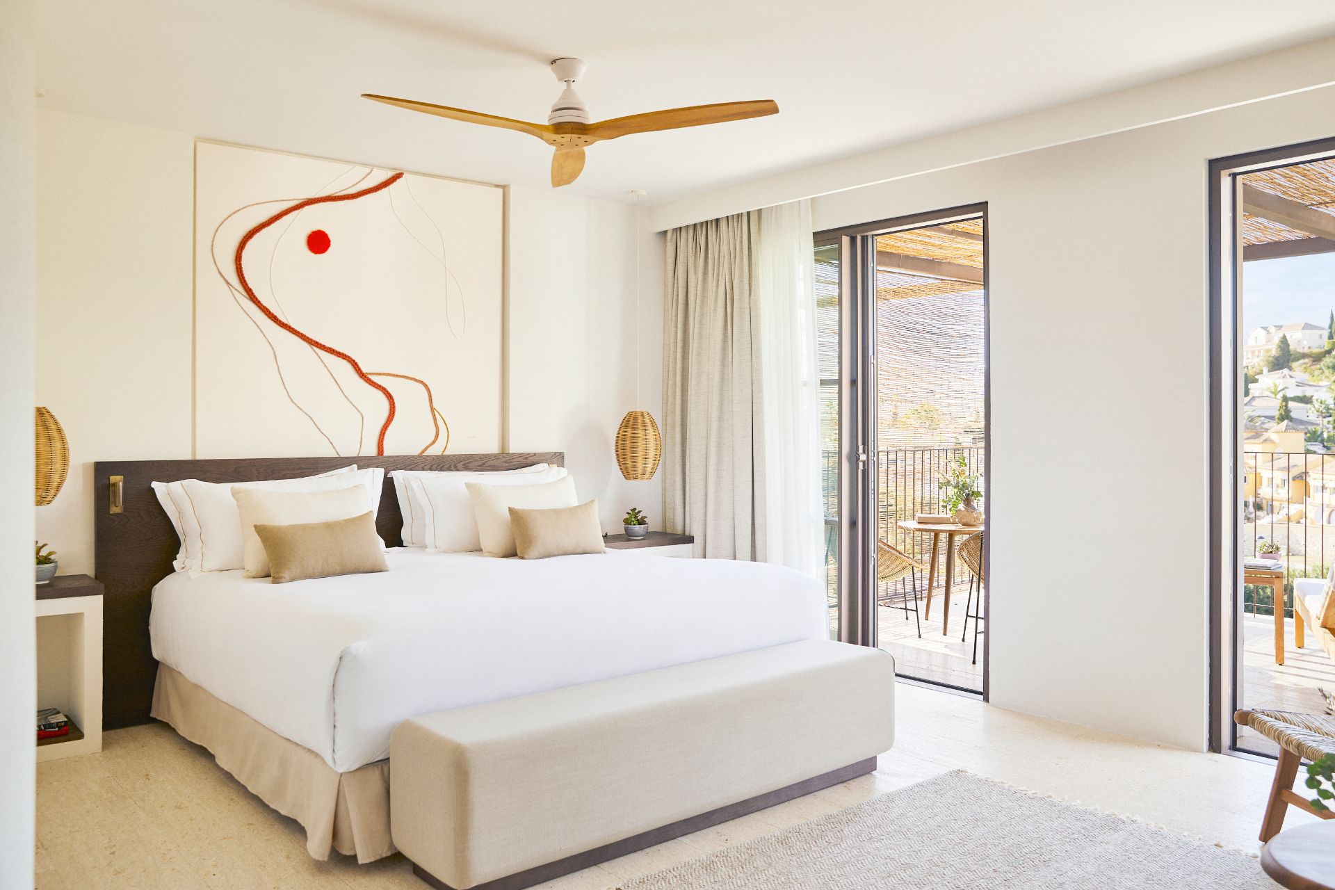 White bedroom with orange accents and floor-to-ceiling windows.