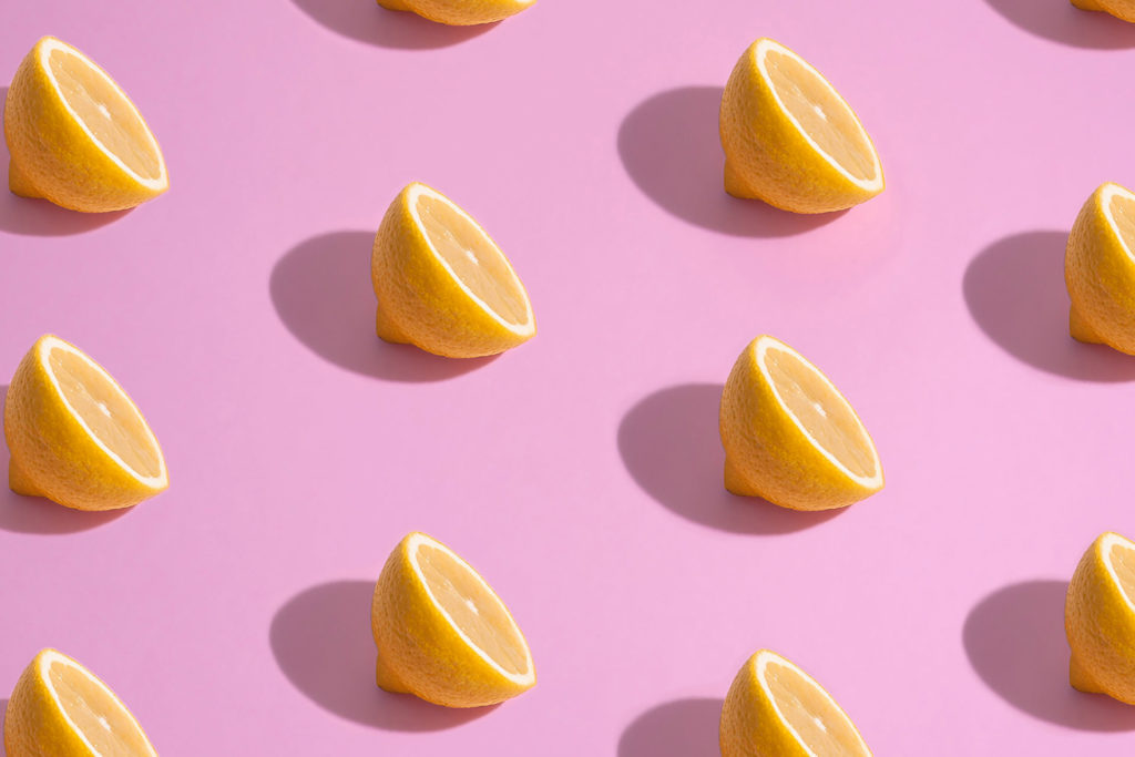 Sliced lemons on a pink background