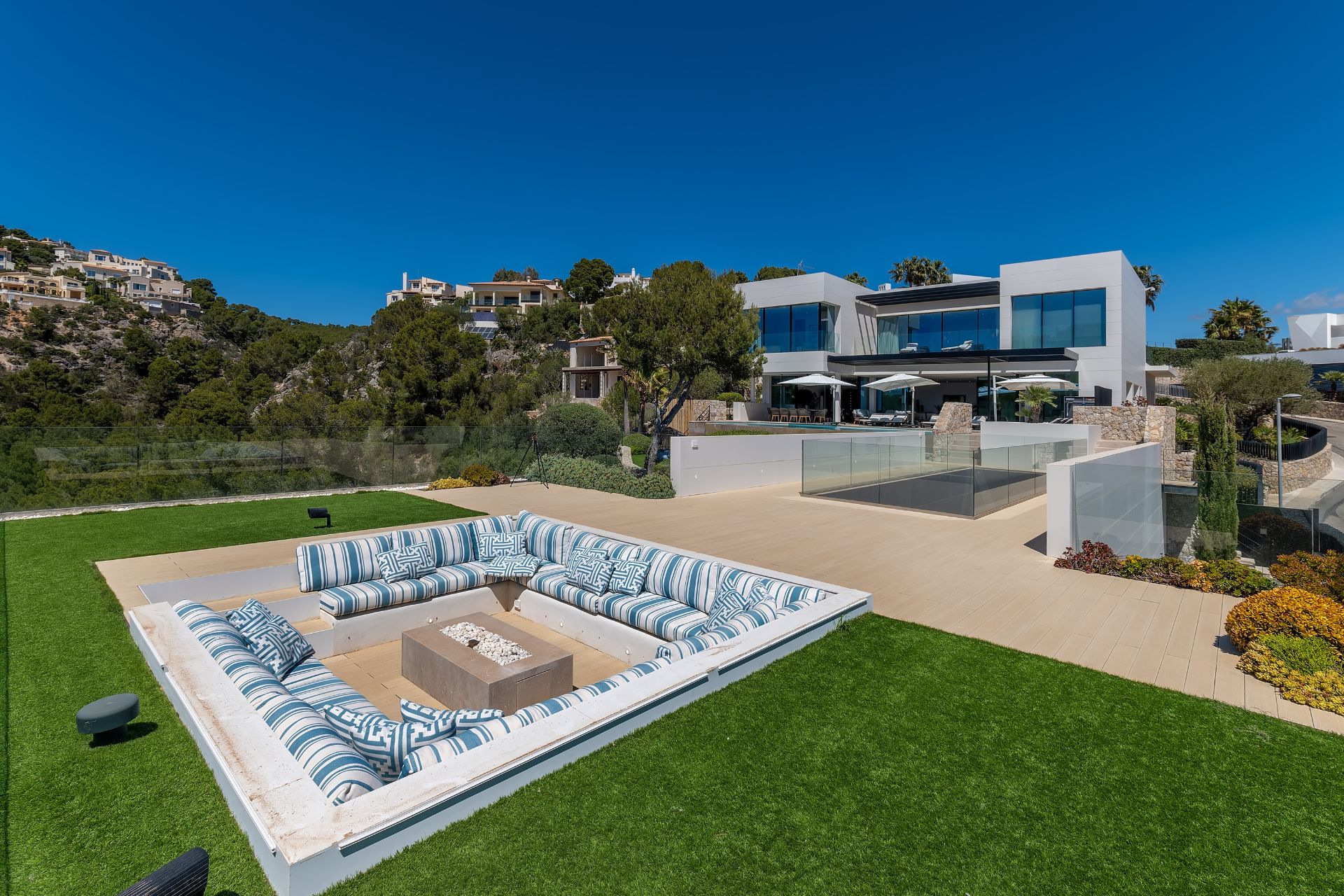 Large Mallorcan villa with a pool and a sunken seating area built into the lawn.
