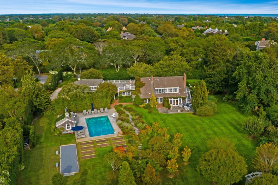 Aerial view of barn conversion with lawns, pool and roof terrace.