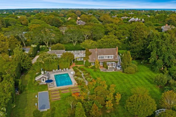 Aerial view of barn conversion with lawns, pool and roof terrace.