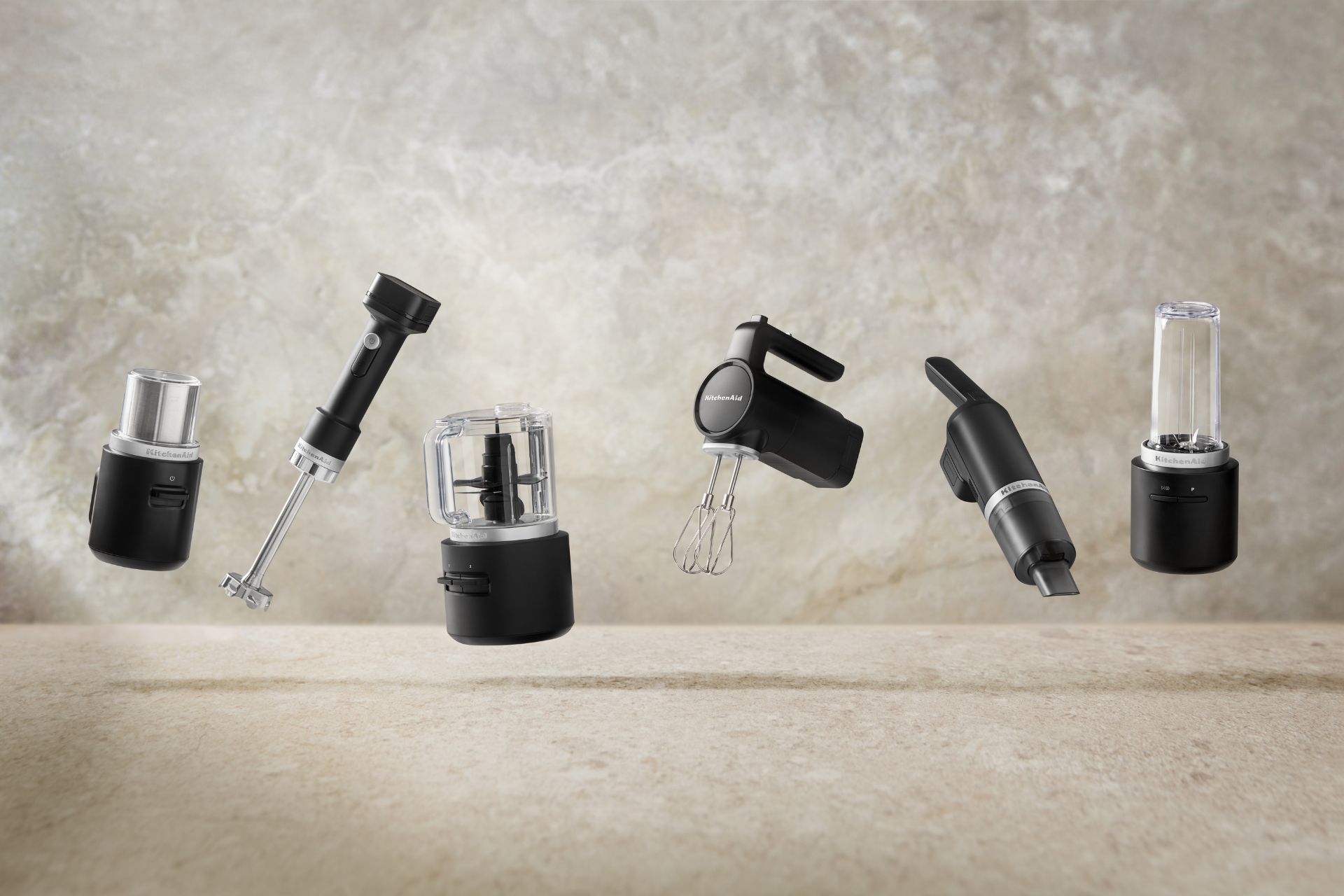 Matte black KitchenAid appliance against a beige marble background
