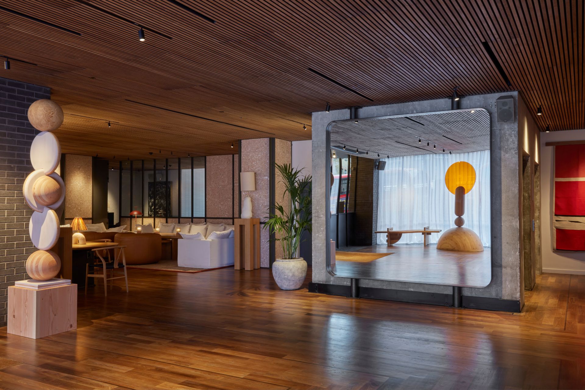 Lobby with wood panelled ceiling, wooden totem sculptures and a large mirror.
