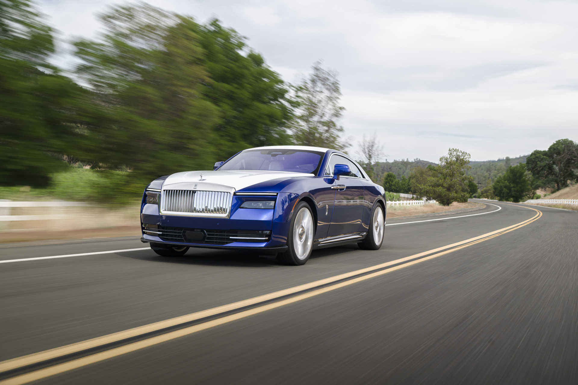 Rolls Royce Spectre driving down a road