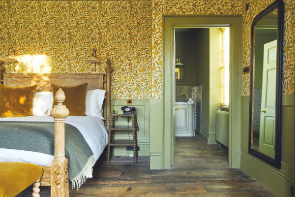 Bedroom with lemon wallpaper at The Pig Near Bath