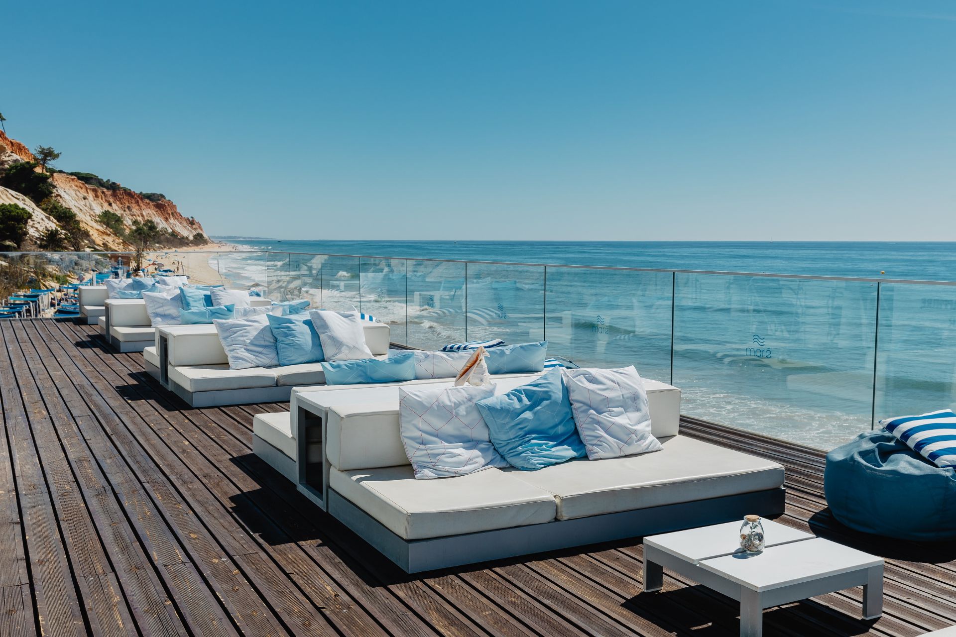 Terrace with white sofas, blue cushions and a sea view.