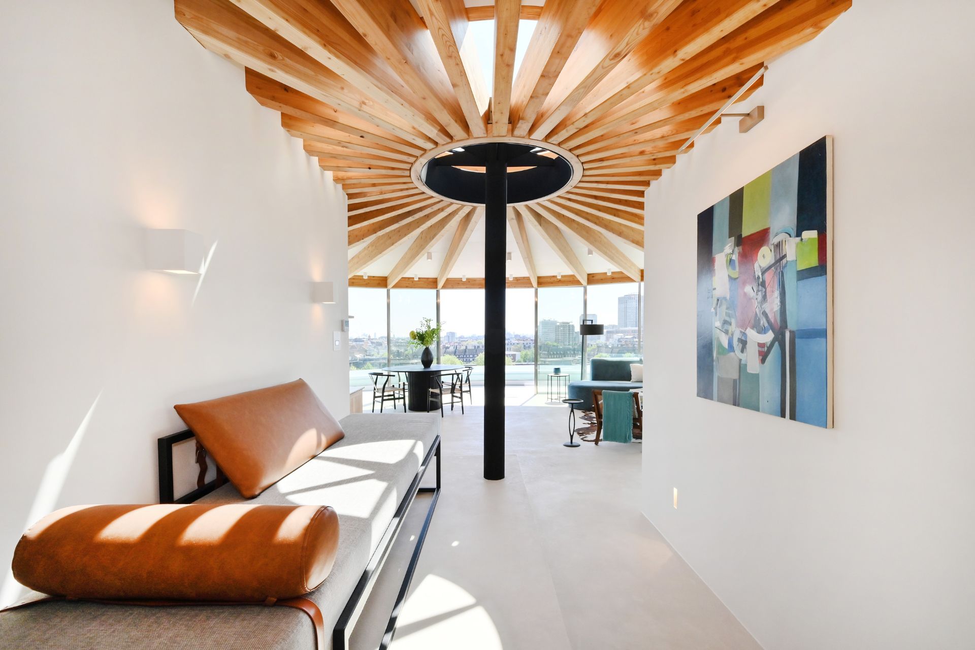 Penthouse living room with wooden ceiling beams arranged around a central column