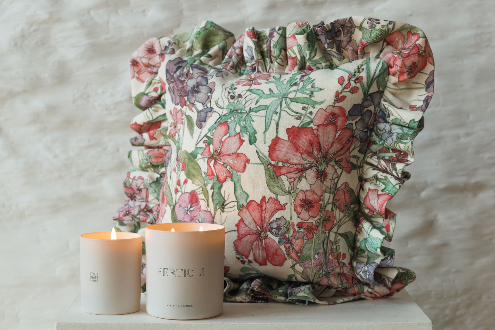 Floral cushion with two white candles in front.