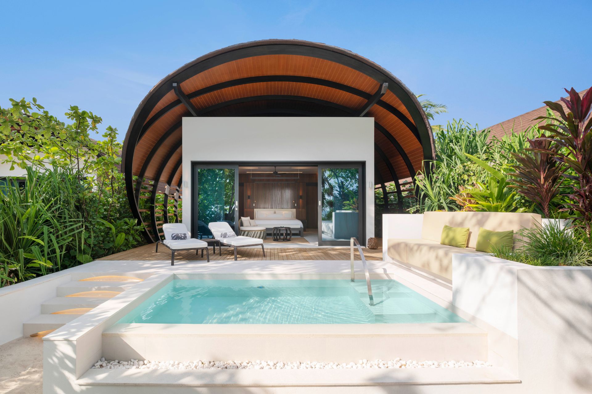 Private pool with sunbeds and trees beyond