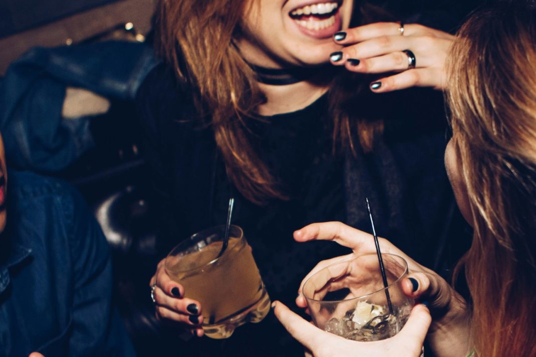 Two women drinking cocktails