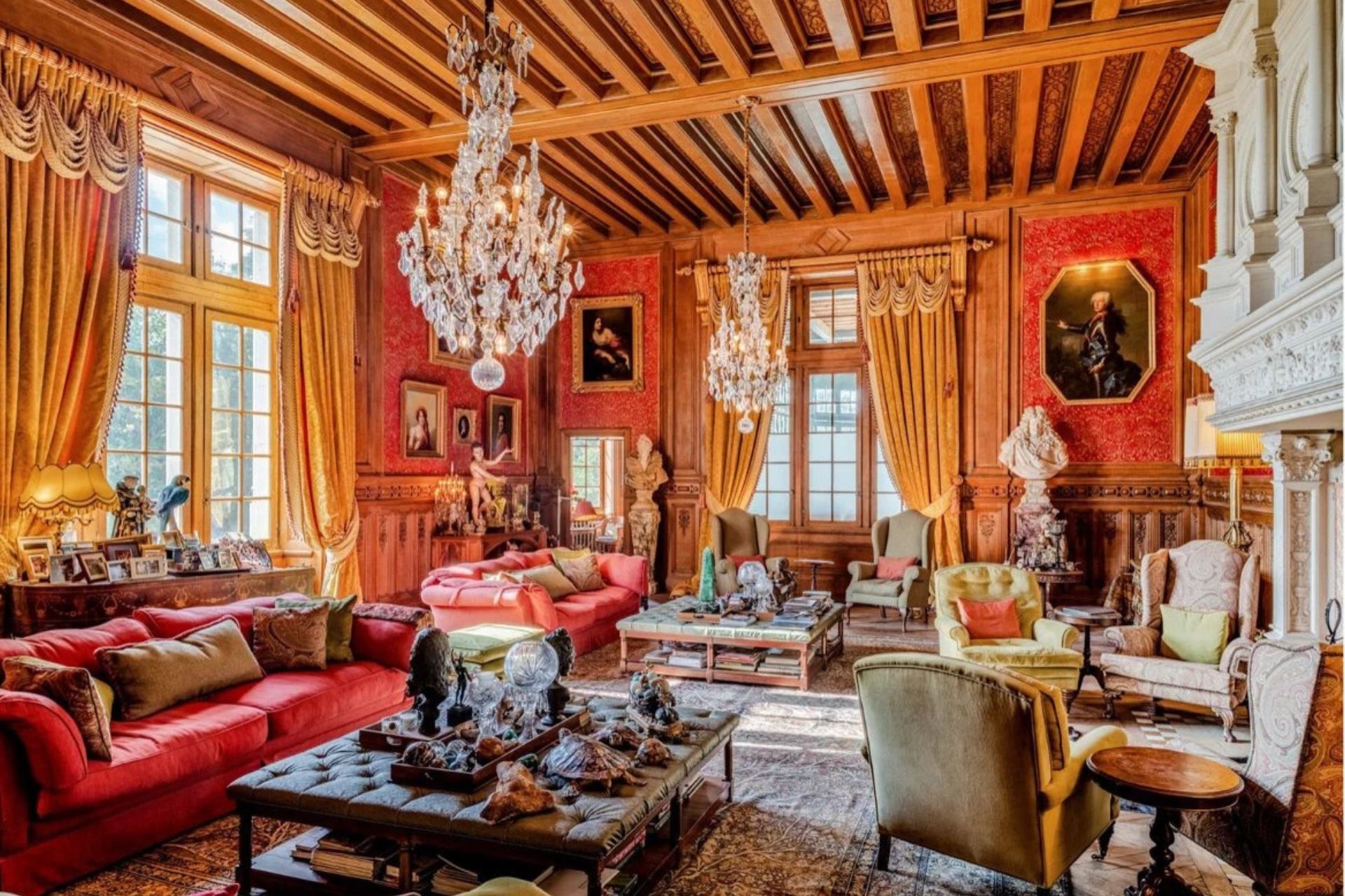Formal reception room with ornate ceilings, chandeliers, and velvet seats.