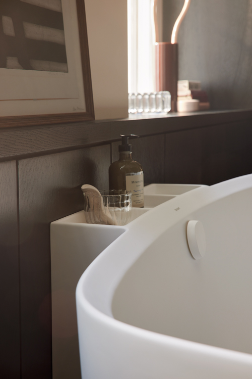 A storage space between a bathtub and the wall