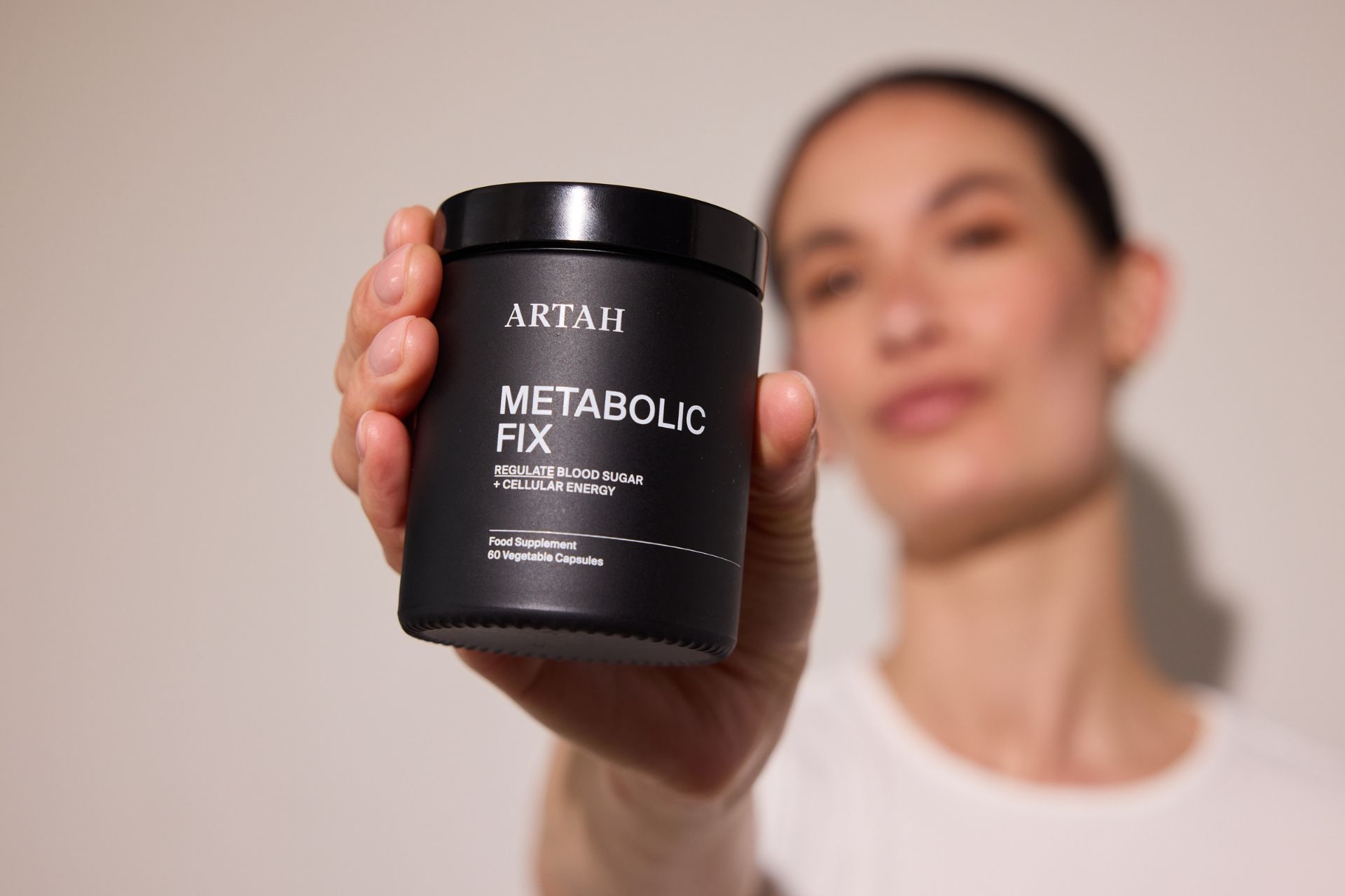 Model holding black Artah supplements