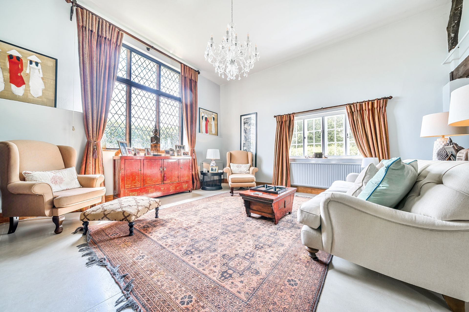 Living room with Persian rug. cream furniture and lead schoolhouse window.