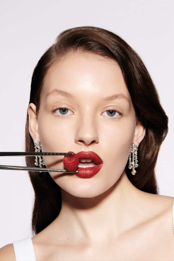 Woman with raspberry held to mouth | longevity diet